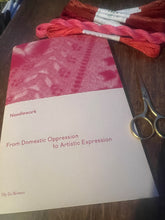 Load image into Gallery viewer, The image shows a book titled &#39;Needlework - From Domestic Oppression to Artistic Expression&#39; laid flat with a pair of scissors, pieces of red linen thread arranged on the table next to it, indicating the theme of needlework.